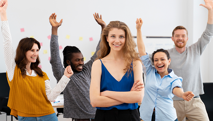 Eine diverse Gruppe von 5 Mitarbeitenden freut sich über die Mitarbeiterbindung im Unternehmen.