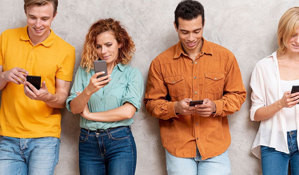 Eine Mobile Befragung wird von einer Gruppe von Menschen am Smartphone oder Tablet ausgefüllt.