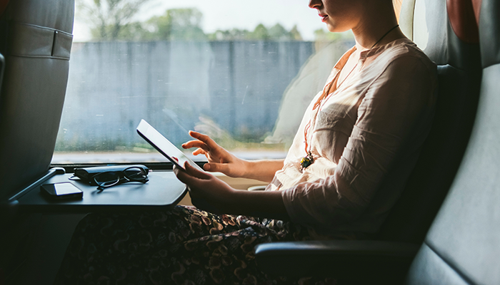 Von unterwegs, in einem Bus sitzend, erledigt eine Mitarbeiterin ihre Aufgaben.