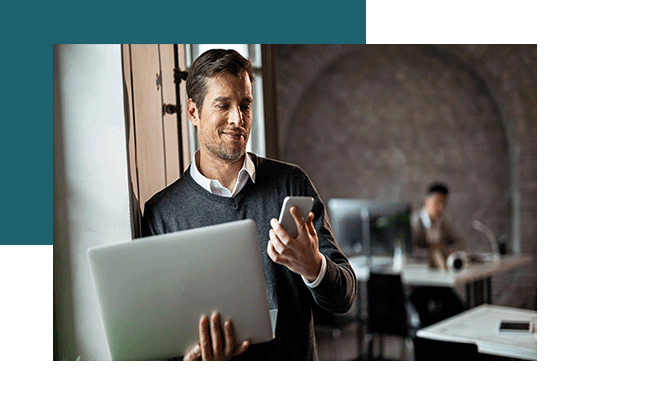 Panel-Studien mit qualitativen Formaten verbinden. Ein Mann hält einen Laptop und ein Handy in seinen Händen.