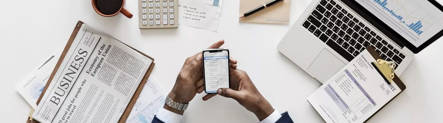 Man sieht einen Schreibtisch mit der aktuellen Zeitpunkt und einem geöffneten Laptop.