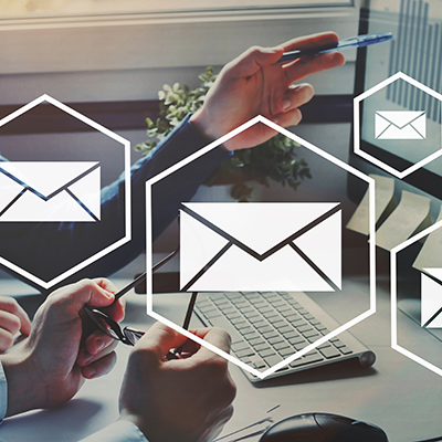 Ein Mann zeigt auf dem PC-Bildschirm Diagramme über die Rücklaufquote der Online-Befragungen.