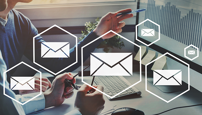 Ein Mann zeigt auf dem PC-Bildschirm Diagramme über die Rücklaufquote der Online-Befragungen.