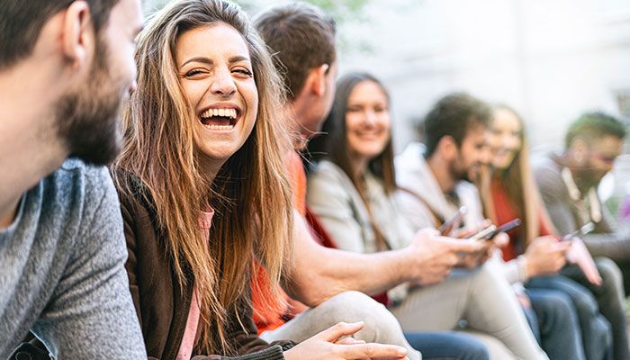 Durch das Verbraucherpanel haben Unternehmen Einblicke in Konsumentenverhalten. Eine Gruppe junger Menschen ist fröhlich und lacht.