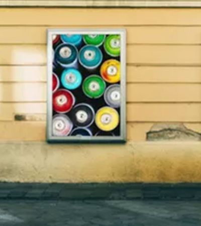 Werbewirkung zu messen, hilft den Erfolg von Werbung zu verstehen. Auf einer Hauswand befinden sich Werbeplakate mit Produkten.