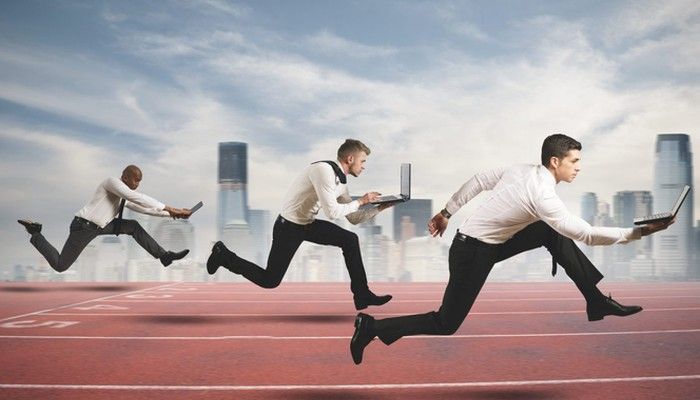 Drei Businessmänner sprinten mit ihren Laptops in der Hand um eine Wettbewerbsanalyse zu symbolisieren.