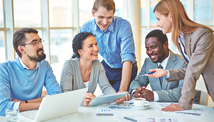 Eine Frau unterstützt eine Gruppe von Mitarbeitern und Mitarbeiterinnen bei der Vorbereitung für eine internationale Mitarbeiterbefragung.