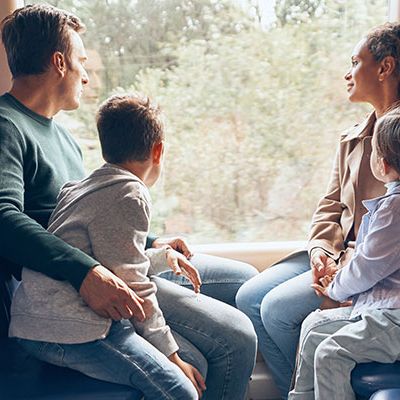 Eine Familie sitzt in einem Zug und macht einen Ausflug mit dem Deutschlandticket.