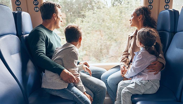 Eine Familie sitzt in einem Zug und macht einen Ausflug mit dem Deutschlandticket.