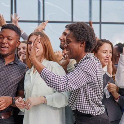 Gelebte erfolgreiche Employee Experience: Mitarbeitende feiern und jubeln zusammen.