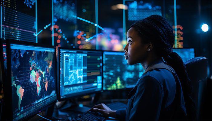 Eine Frau sitz vor Bildschirmen und sieht die Ergebnisse der Feedbackautomatisierung Ihrer Kundenbefragungen an.