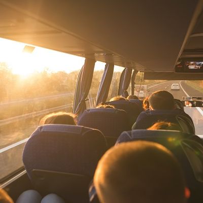 Eine Gruppe sitzt im Fernlinienbus und fährt auf der Autobahn.