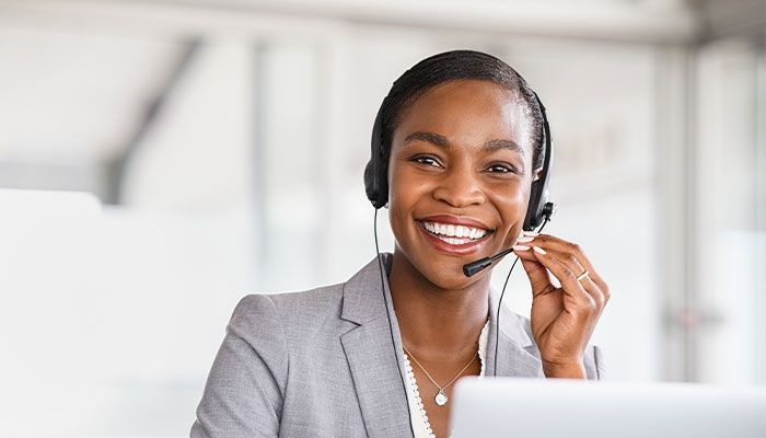 Eine Frau mit einem Headset schaut in die Kamera und symbolisiert die Kundenzentrierung.