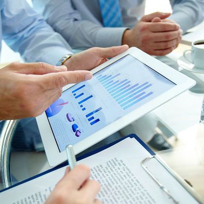 Mehrere Personen schauen sich die Ergebnisse einer Mitarbeiterbefragung im Ipad an.