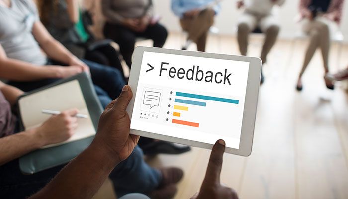 Eine Person schaut sich die Nachfolgeprozesse der Mitarbeiterfeedbacks auf dem Tablet an.