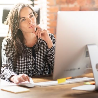 Eine Frau sitzt an ihrem Laptop und prüft die Ergbenisse ihr Panel-Befragung.