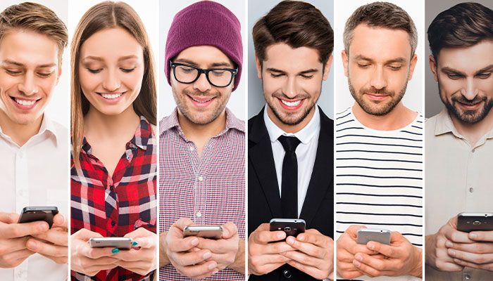 Mehrere Menschen sind an ihren Smartphones und füllen die Schnittstellenbefragung aus.