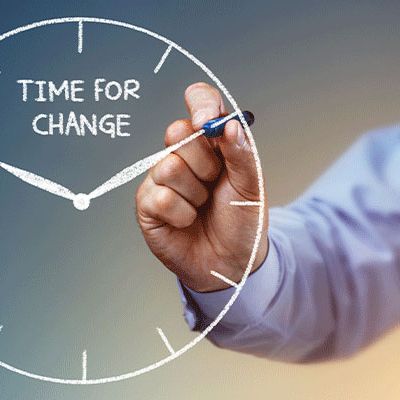 Veränderungsprozesse / Business Man malt mit einem Stift eine Uhr unter der Überschrift "Time for change"