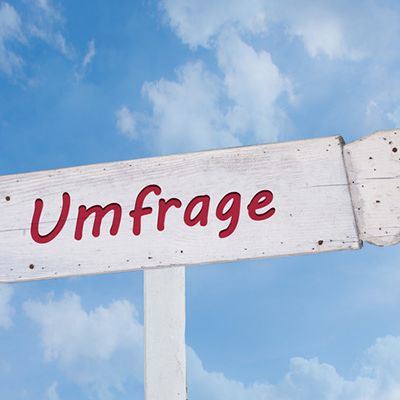 Auf einem Schild steht Fragebogen Mitarbeiterzufriedenheit.