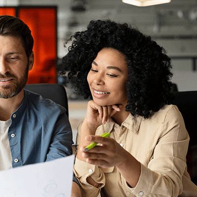 Ein Mann füllt mit einer Frau eine Mitarbeiterbefragung aus.
