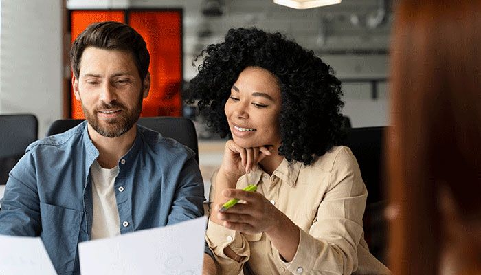 Ein Mann füllt mit einer Frau eine Mitarbeiterbefragung aus.