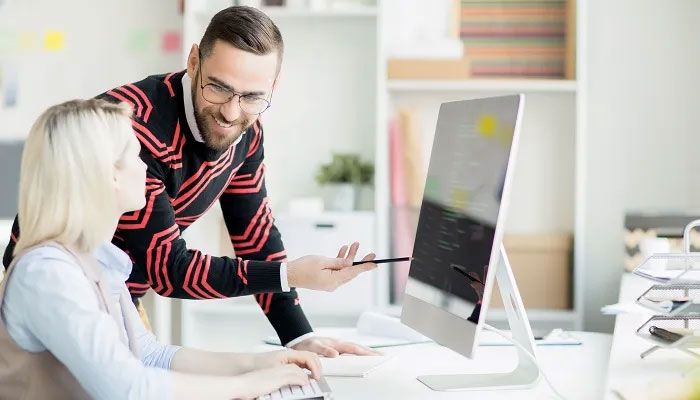 Zwei Kollegen beraten sich am PC