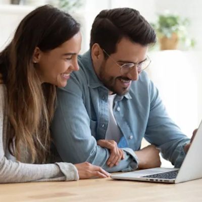 Paar glücklich vor dem Laptop.