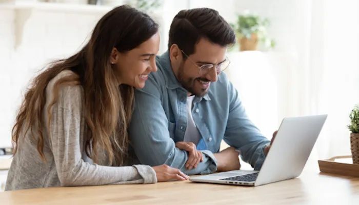 Paar glücklich vor dem Laptop.