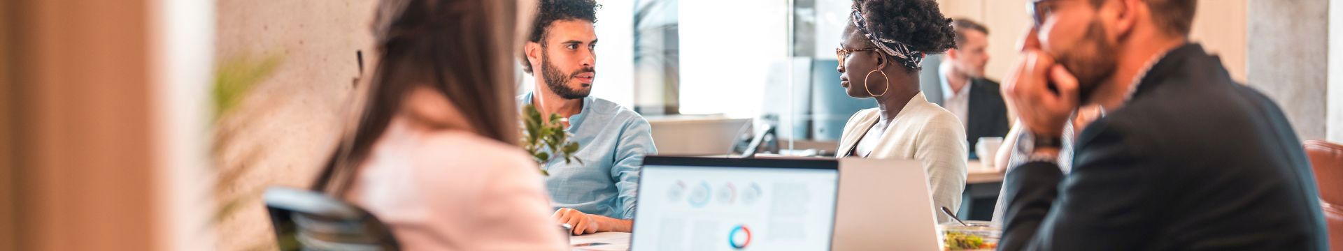 Das Foto zeigt Personen, welche gemeinsam in einem Büro sitzen und sich unterhalten