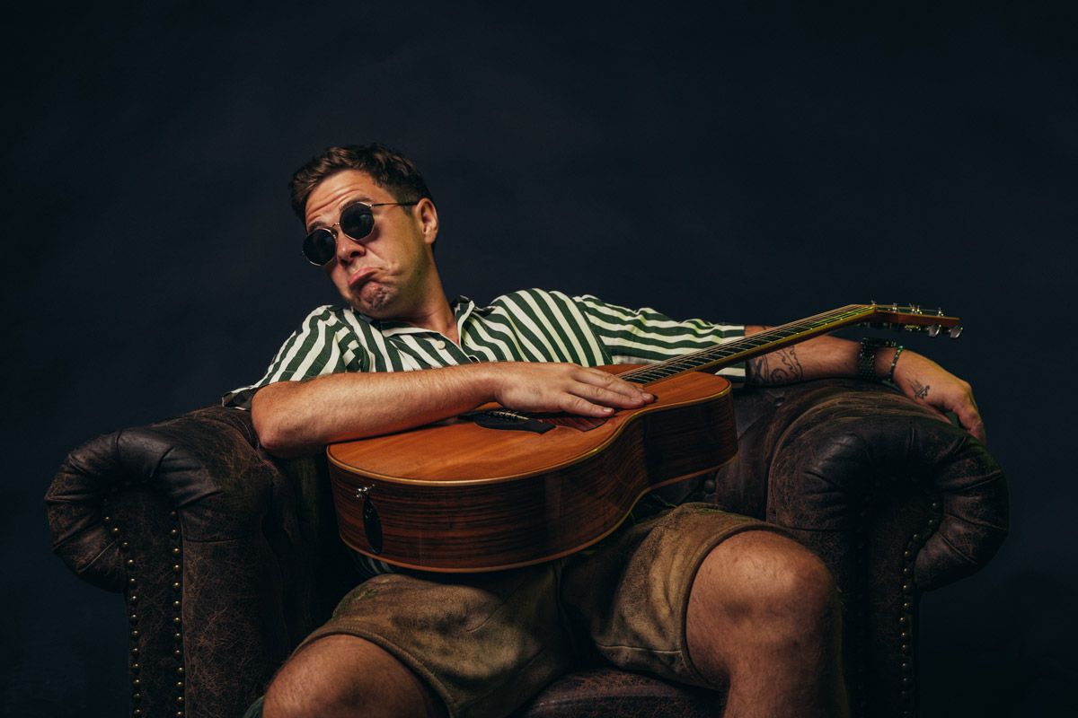 OIMARA mit einer Gitarre auf dem Schoß