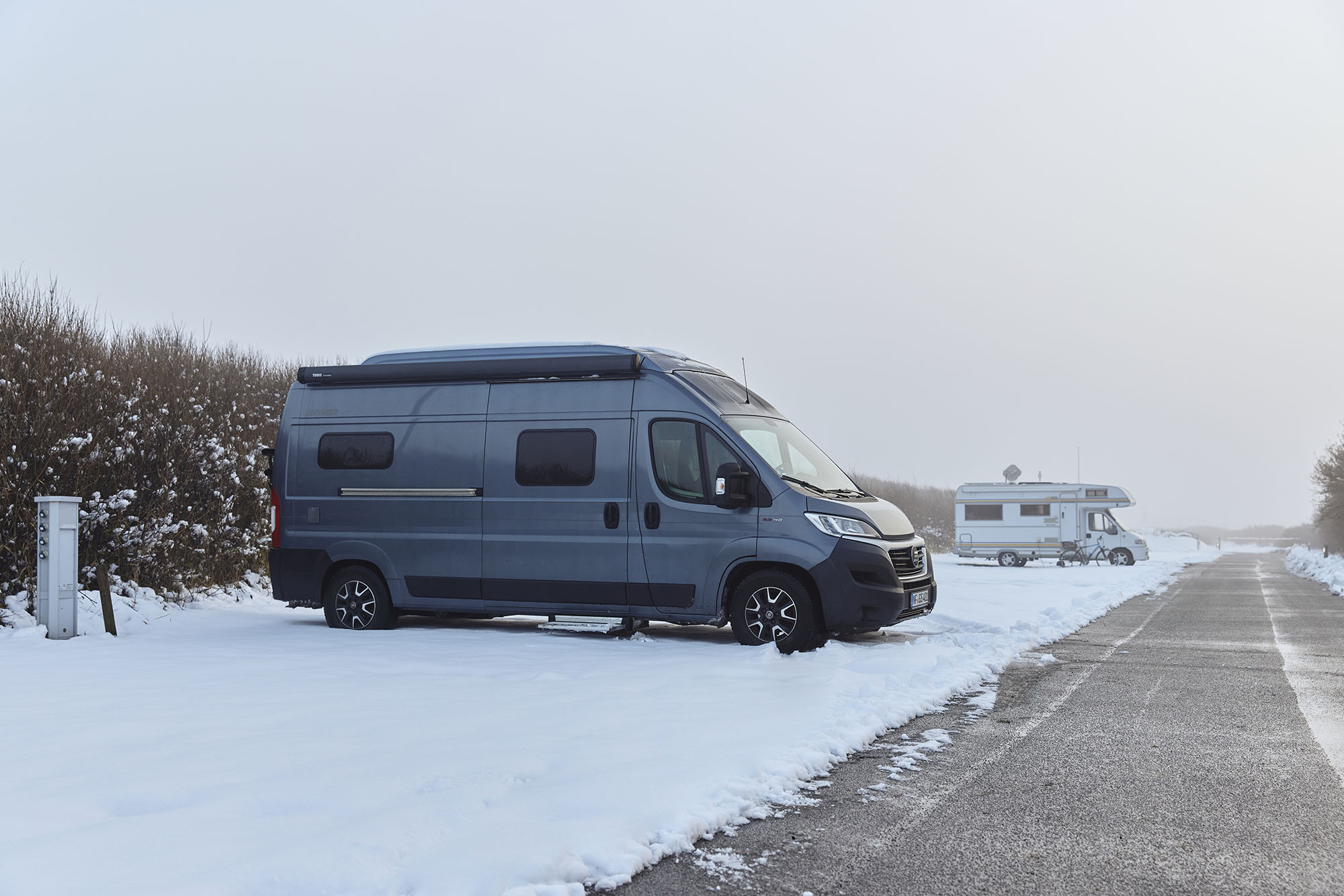 Wohnmobil beim Camping im Winter mit Schnee auf dem Campingplatz Rantum