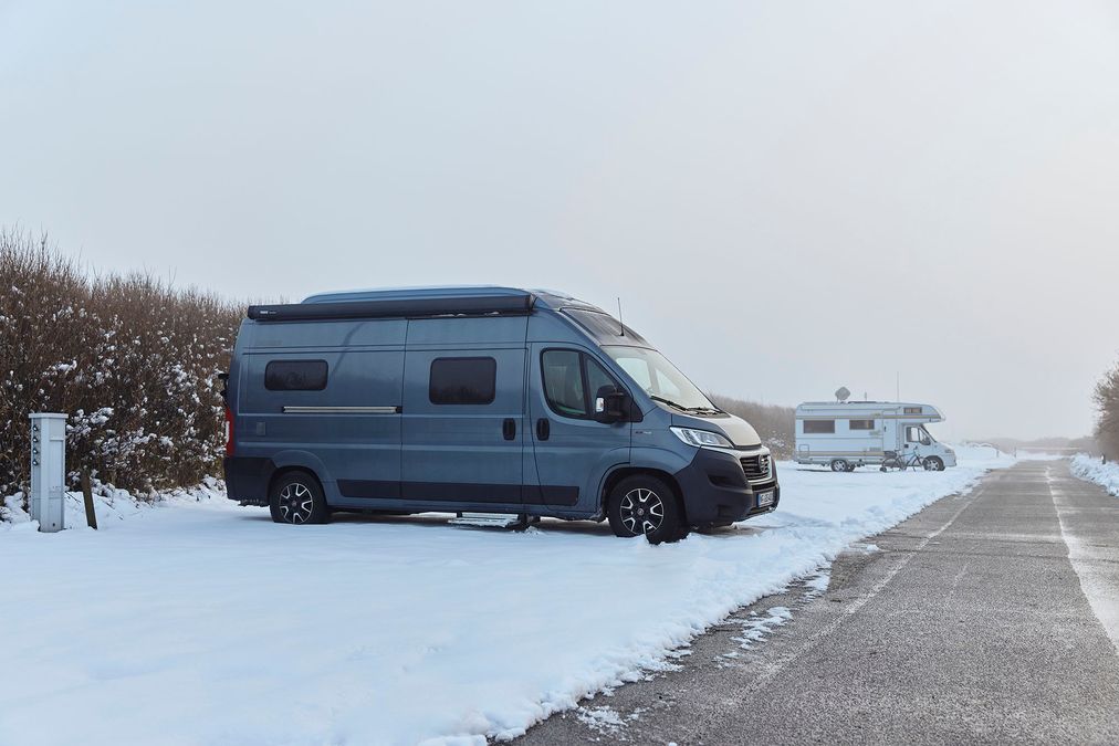 Wohnmobil beim Camping im Winter mit Schnee auf dem Campingplatz Rantum