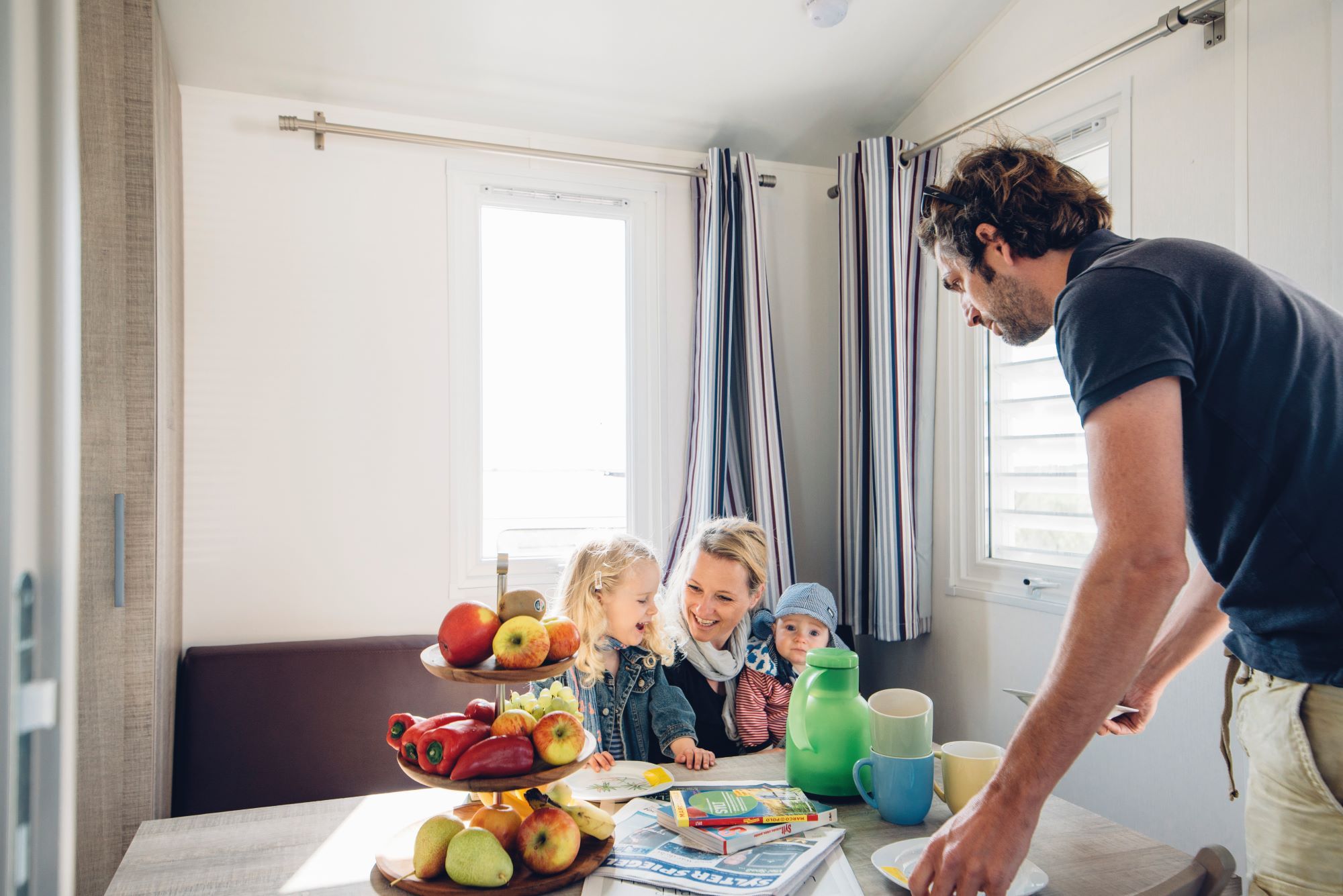 Familie sitzt am Küchentisch im Mobilheim auf dem Campingplatz Rantum