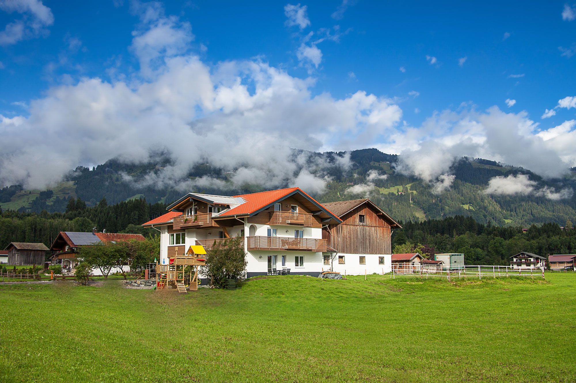Ferienhaus im Grünen mit Spielplatz in Fischen im Allgäu vor idyllischer Berglandschaft – ideal für Familienurlaub in der Natur.