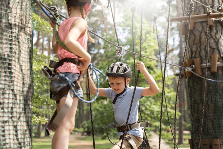 Zwei Kinder beim Klettern im Abenteuerpark in Fischen im Allgäu – aktiver Familienspaß und Bewegung in der Natur für kleine Urlauber.