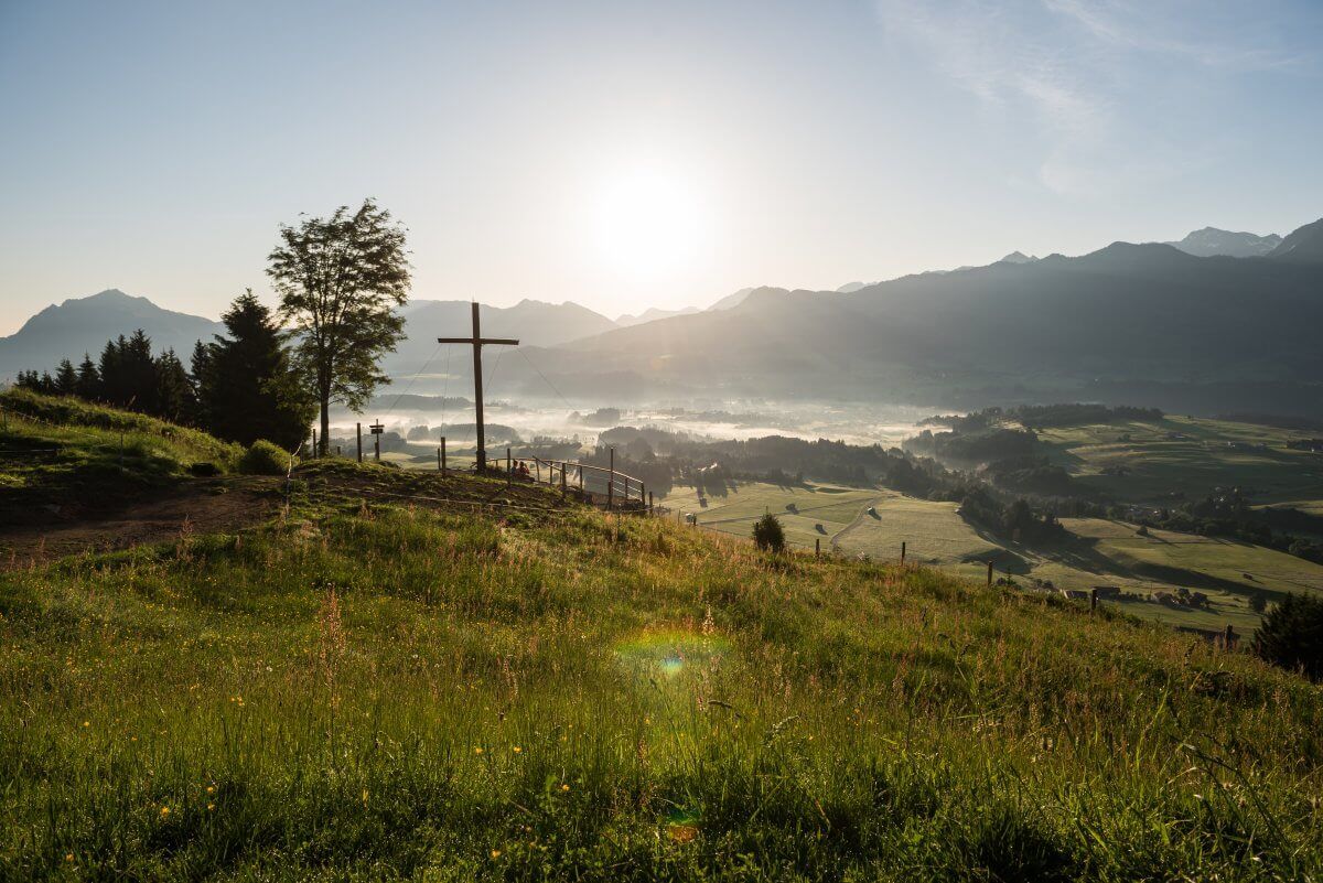 Herbstwanderung bei Sonnenaufgang im Allgäu – Wanderer genießen die bunten Farben und die friedliche Morgenstimmung.