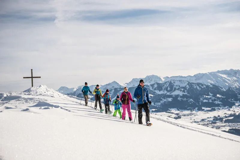 Personen auf Schneeschuh-Tour in Ofterschwang, Allgäu – Winteraktivität in verschneiter Berglandschaft.