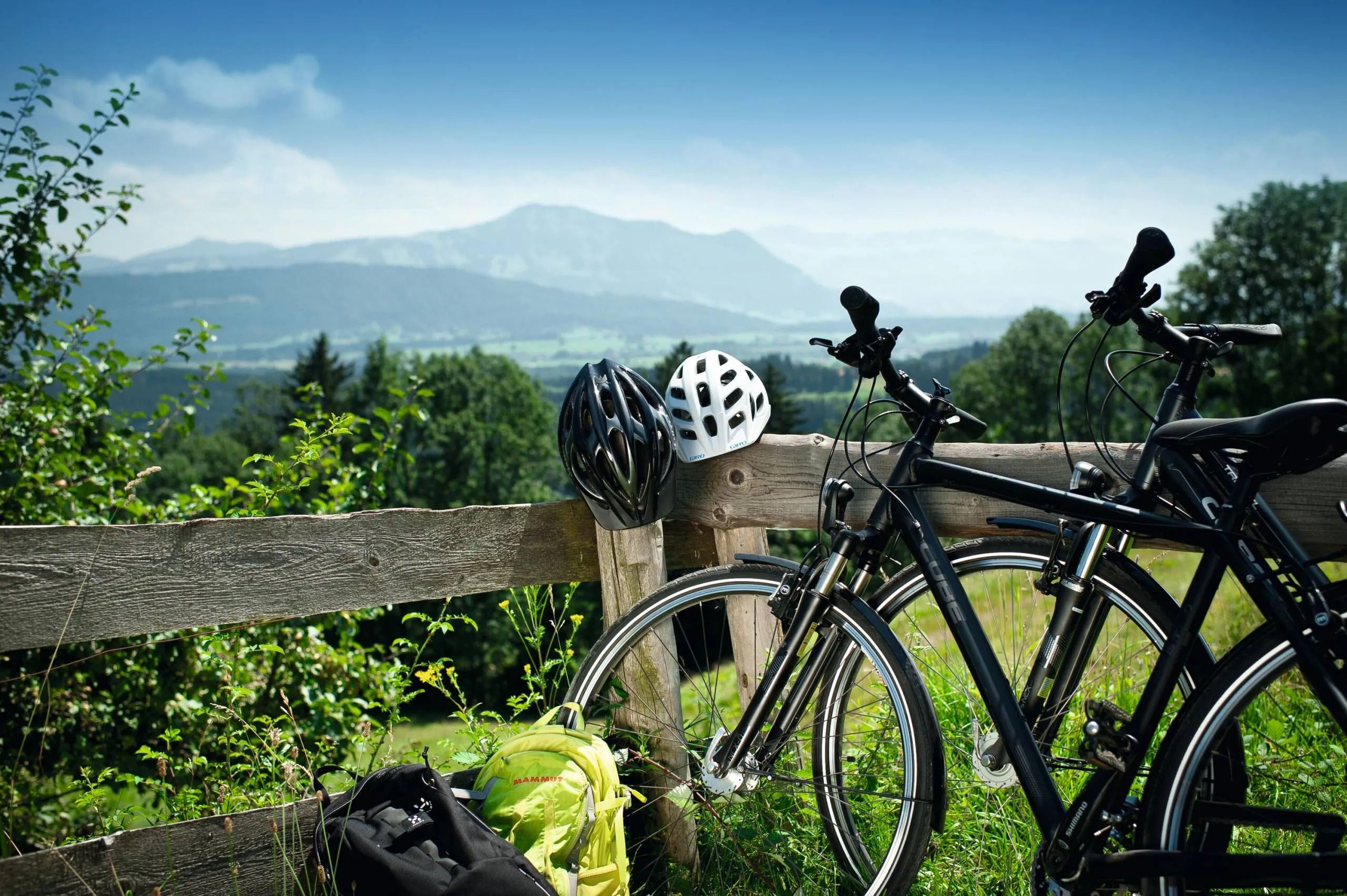Radfahrer machen eine Pause mit Blick auf die beeindruckende Berglandschaft im Allgäu – aktiver Urlaub und Naturgenuss.