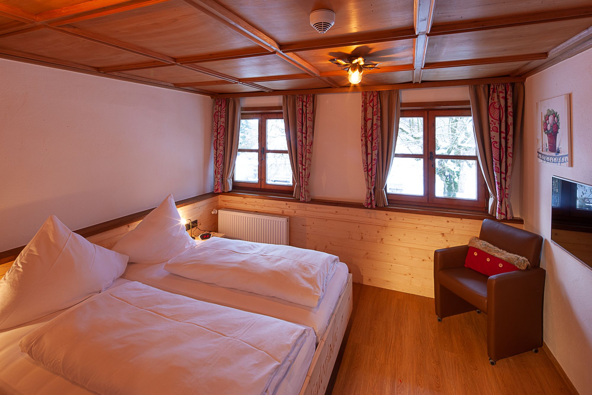 Gemütliches Schlafzimmer mit warmem Licht und Holzoptik – ruhiger Rückzugsort in einer Ferienwohnung im Allgäu.