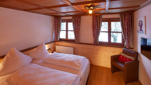 Gemütliches Schlafzimmer mit warmem Licht und Holzoptik – ruhiger Rückzugsort in einer Ferienwohnung im Allgäu.