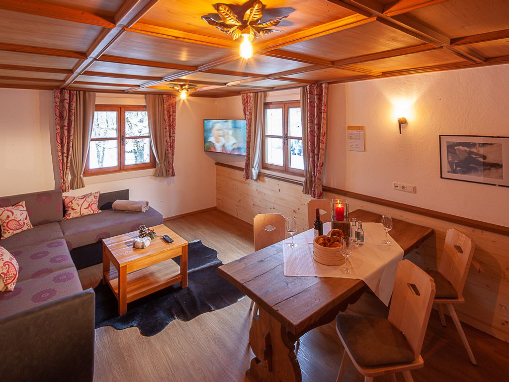 Gemütliches Wohnzimmer mit Holzoptik und warmem Licht, ausgestattet mit moderner Einrichtung – einladender Wohnbereich in einer Ferienwohnung im Allgäu.