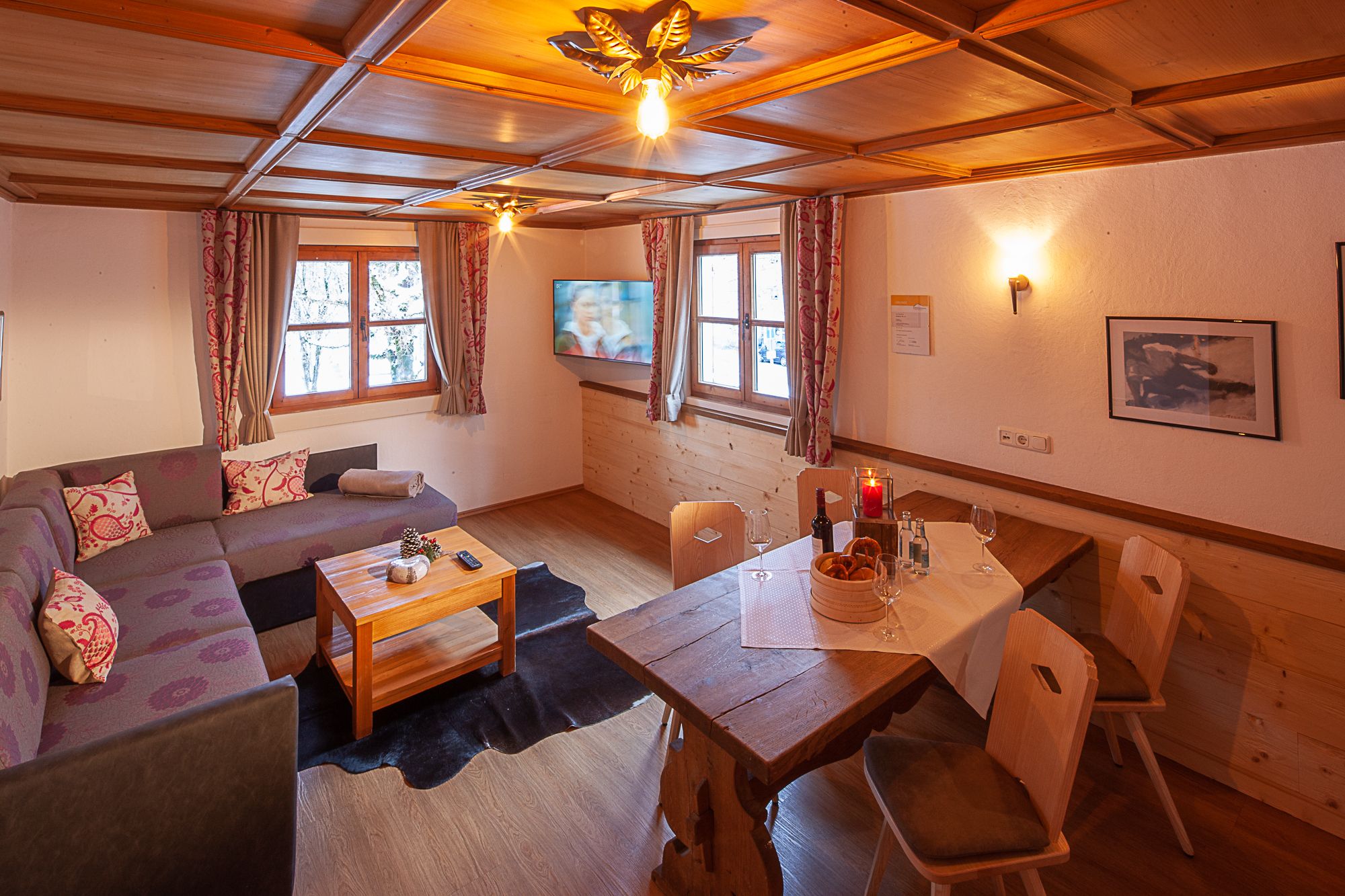 Gemütliches Wohnzimmer mit Holzoptik und warmem Licht, ausgestattet mit moderner Einrichtung – einladender Wohnbereich in einer Ferienwohnung im Allgäu.