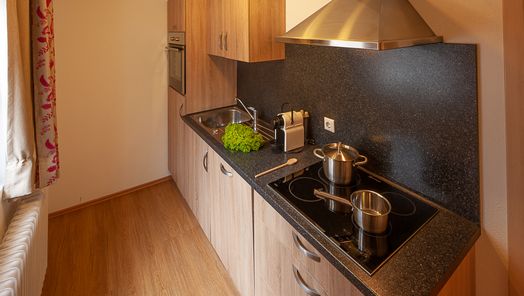 Moderne, voll ausgestattete Küche mit Holzoptik und allen wichtigen Geräten – ideal für Selbstversorger in einer Ferienwohnung im Allgäu.