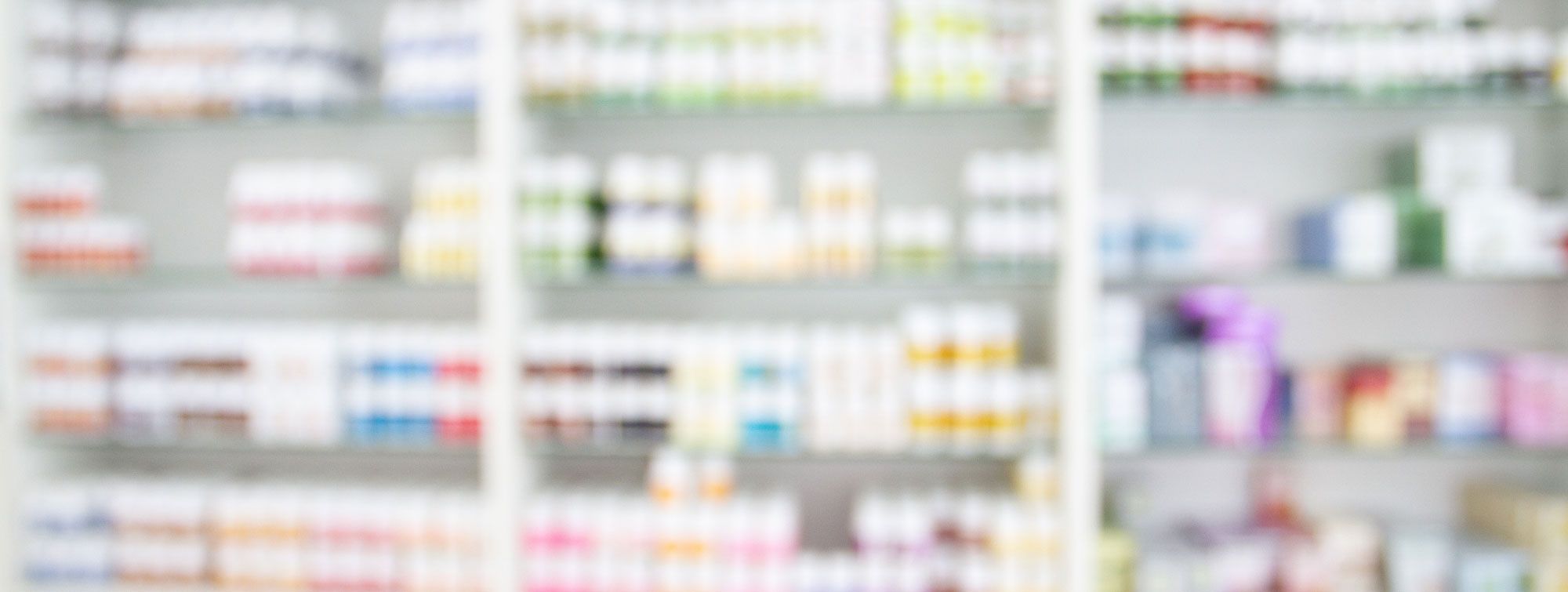 ein unscharfes Apothekenregal mit bunten Packungen