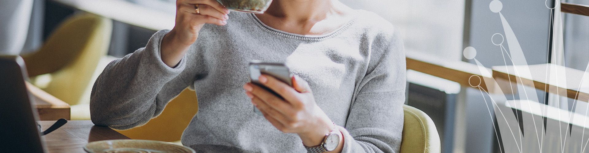 Eine Person trinkt Kaffee und liest im Smartphone