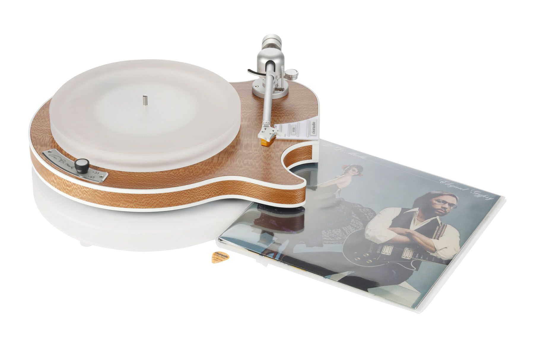 Ein eleganter High-End-Plattenspieler von Clearaudio, dessen Chassis der ikonischen Form einer E-Gitarre nachempfunden ist. Daneben liegt ein Vinyl-Album des Künstlers Al Di Meola.