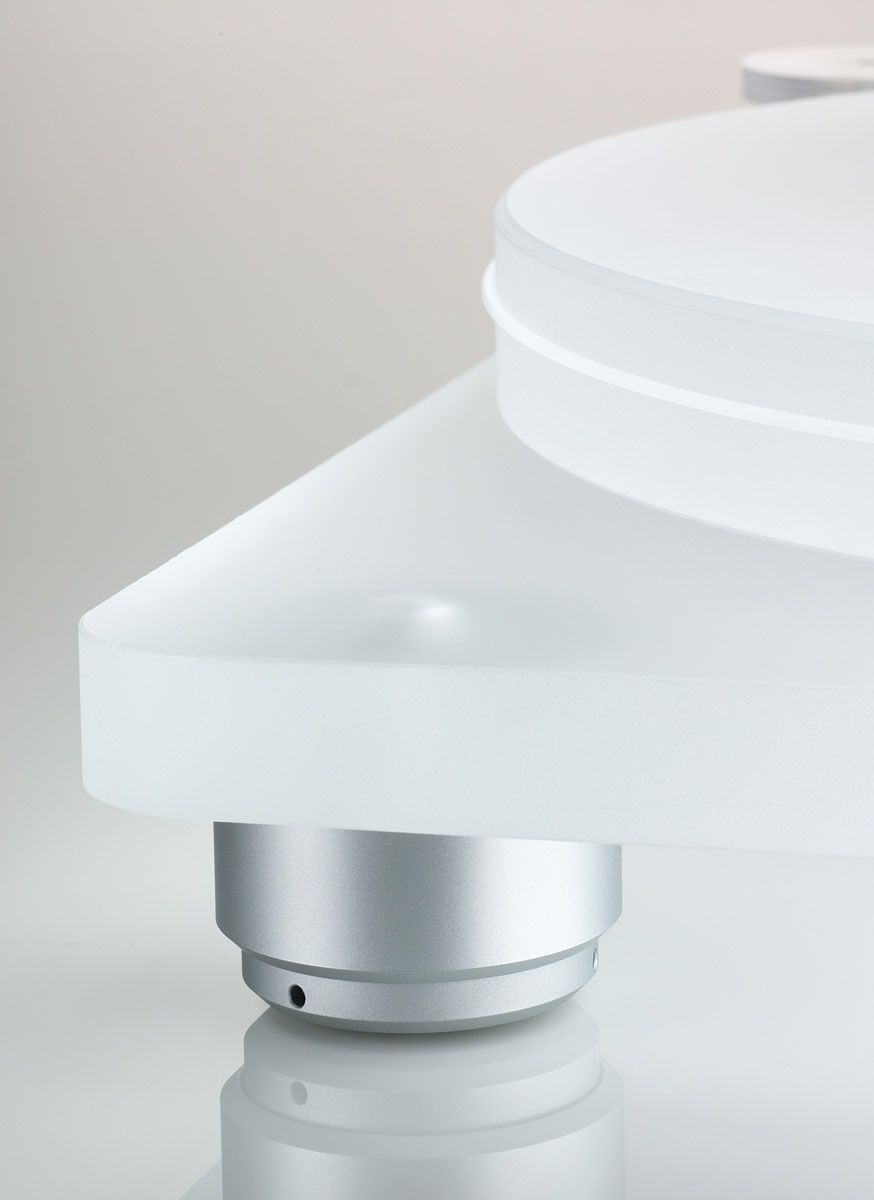 Eine Schrägansicht des Clearaudio Emotion SE Plattenspielers, die die Schichtbauweise der matten Acrylzarge zeigt. Ein massiver, polierter Gleichstrommotor ist in die Zarge integriert und bildet einen visuellen Kontrast zum Acryl. Ein Teil des Präzisions-Innentellers ist sichtbar.