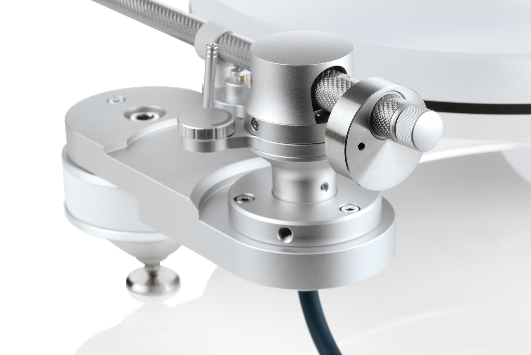 Nahaufnahme der silbernen, präzise gefrästen Tonarmbasis und des Lagers eines Clearaudio Drehtonarms auf dem hellen Innovation Basic Chassis.