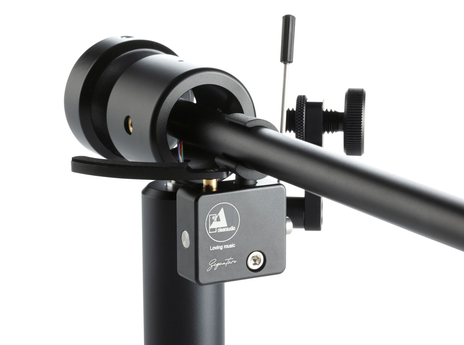 Eine technische Nahaufnahme der kardanischen Lagerung und des Tonarmlifts eines schwarzen High-End-Tonarms. Der Tonarm ist auf einem schwarzen Zylindersockel montiert. Im Vordergrund befindet sich ein rechteckiger schwarzer Gehäuseblock unter dem Tonarmrohr, auf dem das Clearaudio-Logo und der Text „clearaudio“, „Loving music“ und „Signature“ eingraviert sind. Links ist der geschwungene schwarze Hebel des Tonarmlifts zu sehen. Rechts führt eine dünne silberne Stange mit einem schwarzen Einstellknopf nach oben, daneben ein weiterer schwarzer, gerändelter Einstellknopf. Der Hintergrund ist rein weiß.