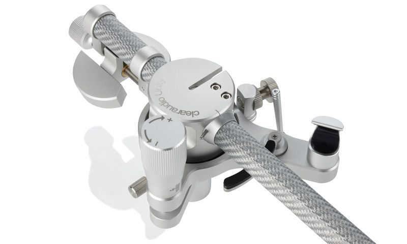 Nahaufnahme des silbernen clearaudio Unity Tonarms, an dem ein Diamond-Jubilee-Tonabnehmer montiert ist, präsentiert auf weißem Hintergrund mit leichter Spiegelung.